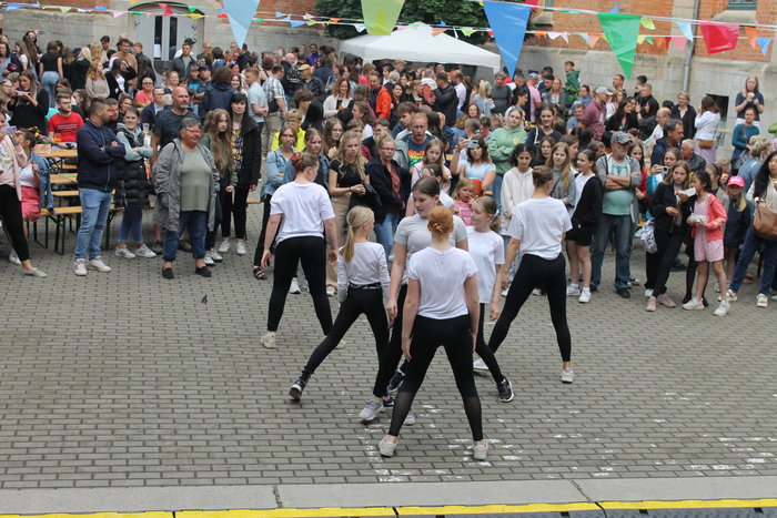 Schülerinnen mit weißen T-Shirt und schwarzen Hosen tanzen beim Hoffest