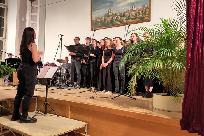 Der Chor der zwölfen Klassenstufe tritt in der Aula im Käthe-Kollwitz-Haus auf.
