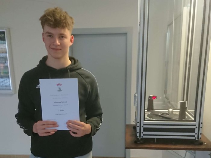 Schüler Johannes Schmidt mit der Urkunde des 3.Platzes der Physikolympiade 2023