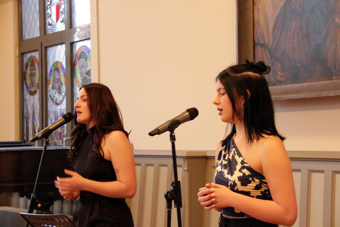 Zwei dunkelhaarige Schülerinnen singen