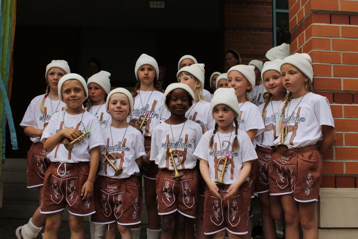 Gruppenfoto von Schülerinnen und Schülern mit weißen Mützen, T-Shirt und Lederhosen