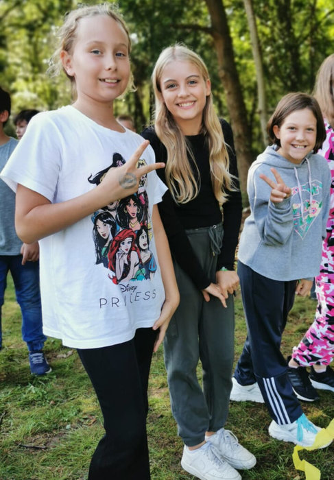 Drei Schülerinnen lächeln in die Kamera