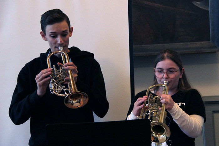 Eine Schülerin und ein Schüler spielen ein Blasinstrument