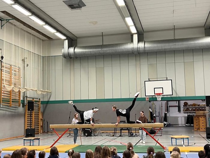 Zwei Schülerinnen turnen auf einem Balken