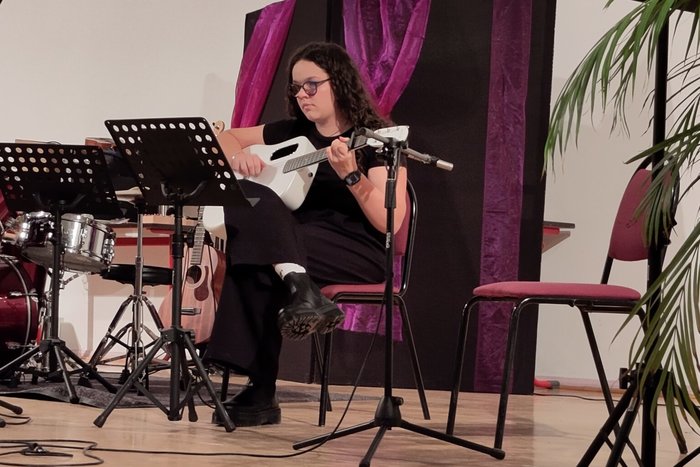 Eine Schülerin trägt eine akustischen Gitarrenstück vor.