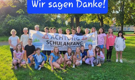 Schülerinnen und Schüler halte ein Plakat mit "Achtung Schulanfang" hoch