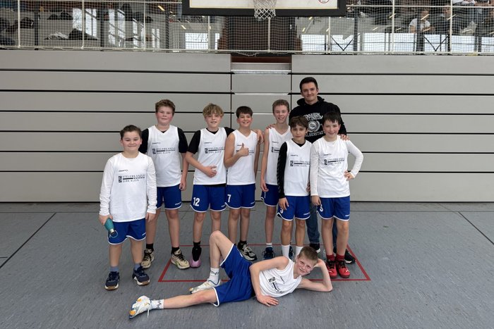 Gruppenfoto des Basketballteams in der Sporthalle.
