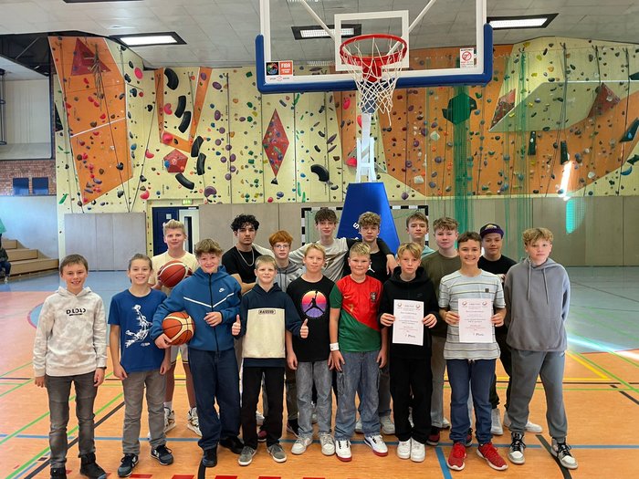 Schüler der Basketballmannschaft stehen in der Turnhalle